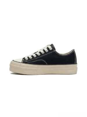 Black cork midsole canvas sneaker left side profile view showing creamy white thick rubber outsole white toe cap and lace-up design