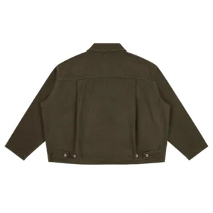 Back view of a cotton canvas boxy workwear jacket showing rear yoke seam, dropped sleeves, and adjustable hem tabs