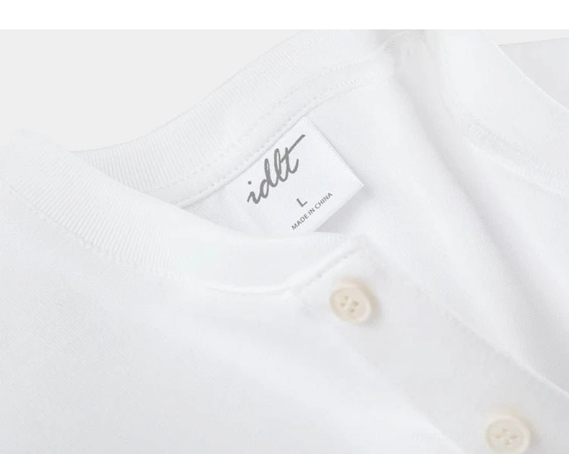 Close-up side view of cotton Henley neckline and three-button placket showing smooth textile finish