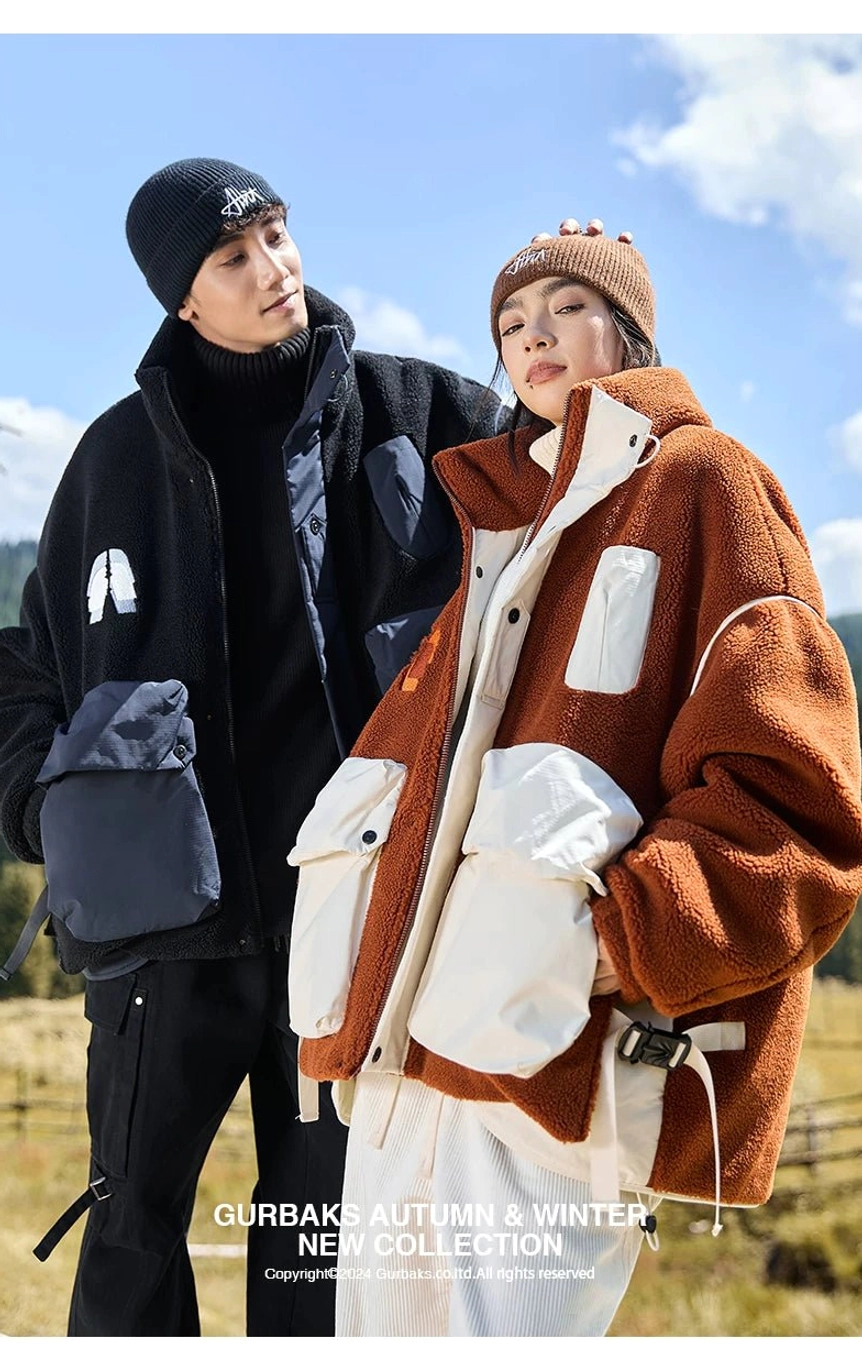 Couple wearing coordinated winter sherpa outerwear in black and contrast tones during an outdoor grassland shoot