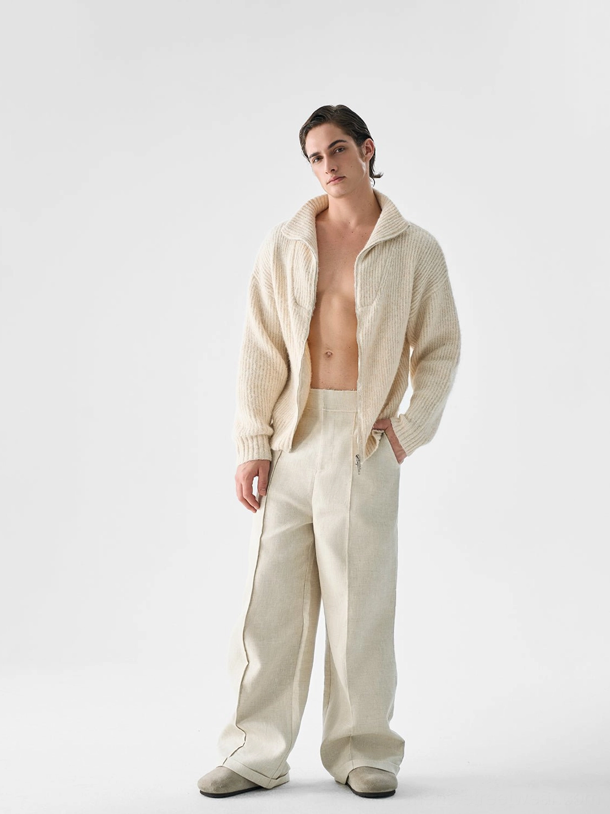 Cream beige loose-fit zip-up knit cardigan sweater for men styled with wide-leg trousers in minimalist Korean streetwear look