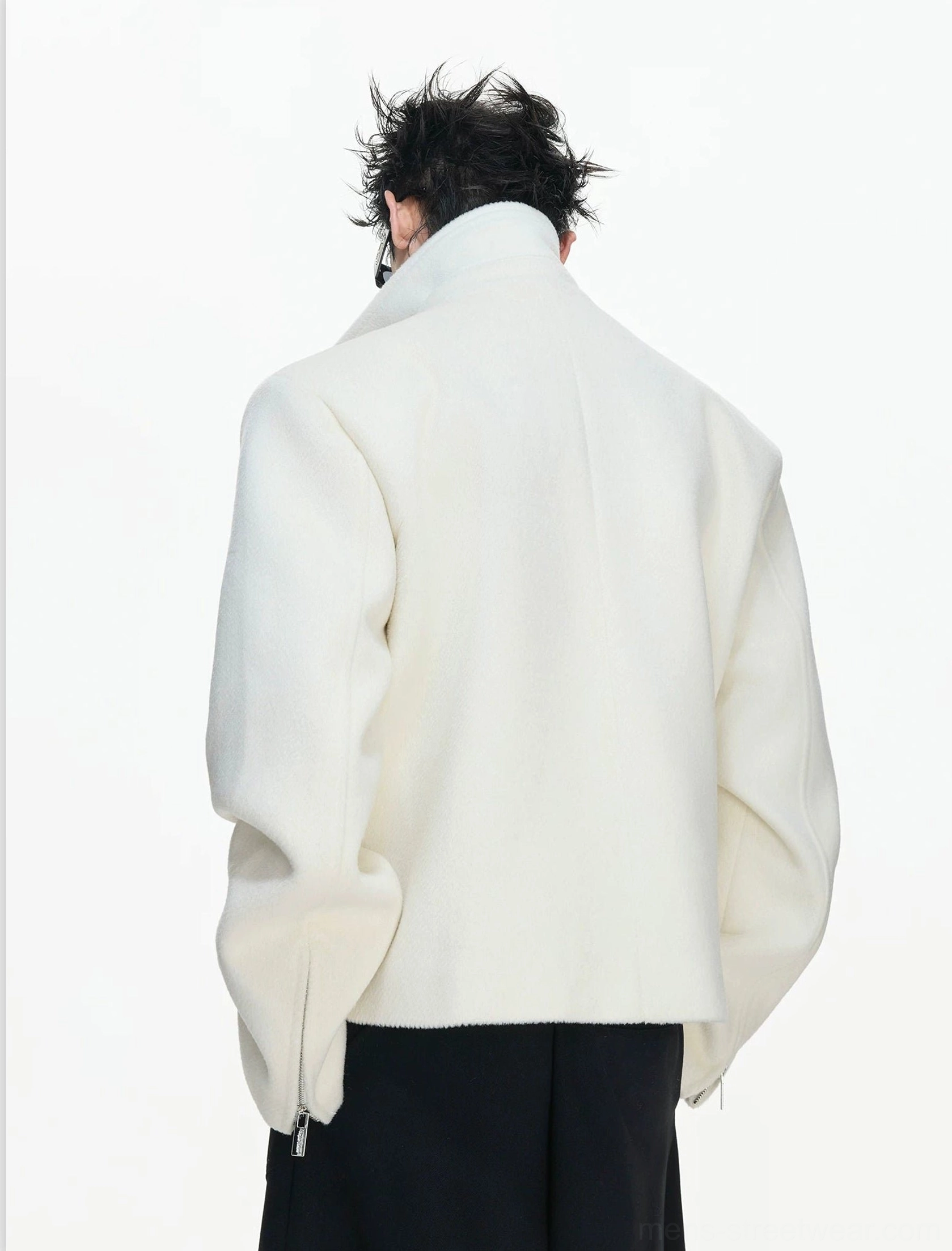 Back view of a cream white cropped wool jacket showing structured shoulders wide collar and zipped sleeve cuffs