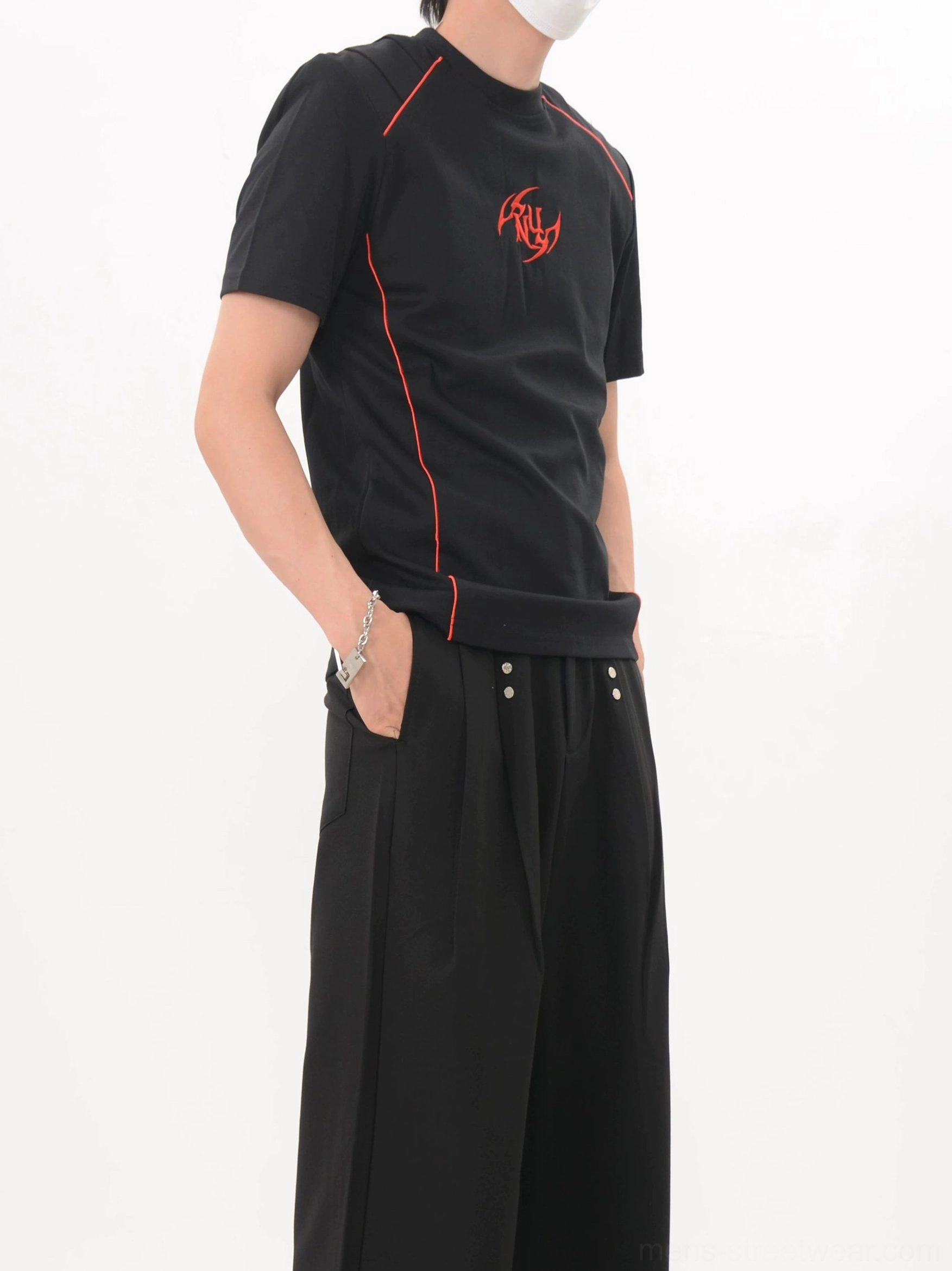 Black Crimson Circuit graphic tee shown from a side three-quarter angle with red chest emblem and structured seam details