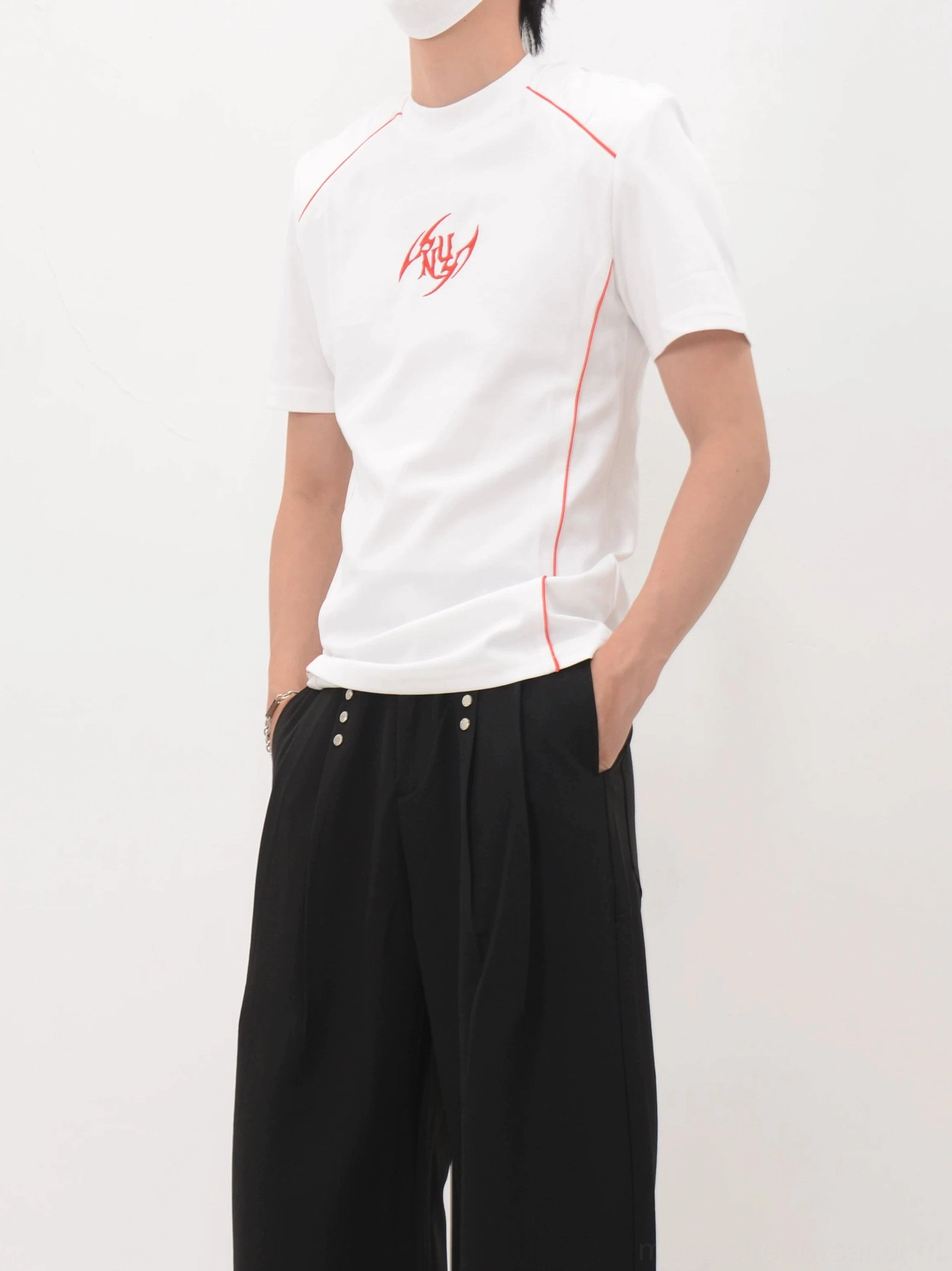 White racing-inspired graphic T-shirt shown from the side front with red contrast stitching and fitted casual silhouette
