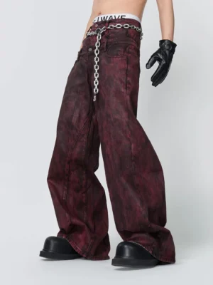 Front three quarter view of crimson haze maroon washed wide leg jeans with included metal waist chain and oversized streetwear silhouette