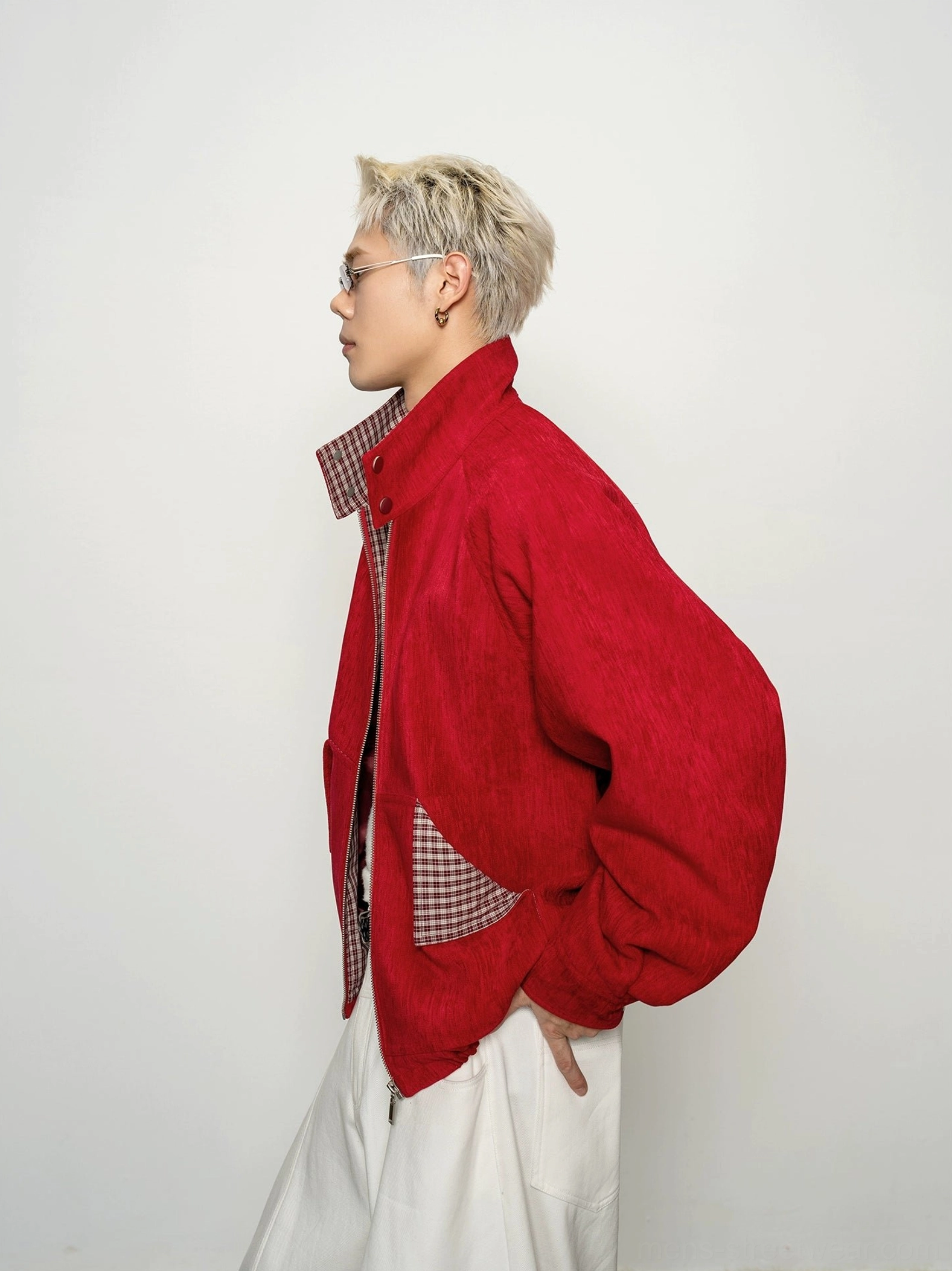Side view of red cropped bomber jacket for men featuring plaid collar lining and side pocket detail