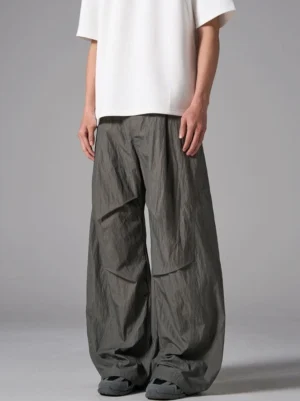 Front three-quarter view of crinkled wide-leg cargo pants with pleated waist and oversized Korean streetwear silhouette