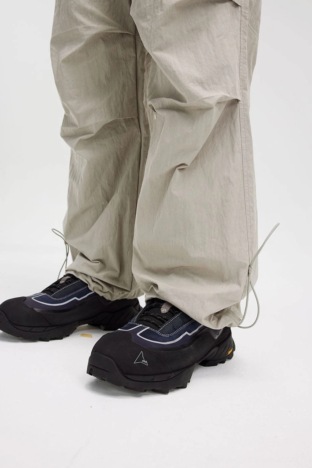 Crinkled wide-leg track pants product view highlighting the loose fit, textured finish, and adjustable ankle hems