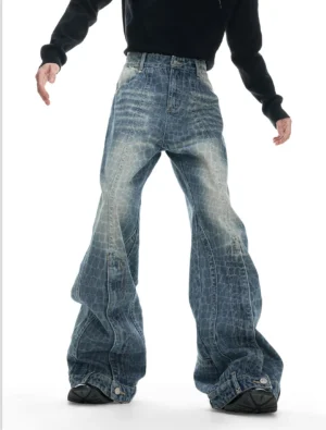Model wearing indigo crocodile texture wide-leg denim trousers with vintage fading, curved vertical seams, adjustable ankle hems, black long-sleeve top, and black streetwear shoes