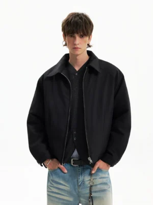 Black cropped minimalist Harrington jacket layered over a knit shirt with light wash distressed jeans in Korean streetwear styling