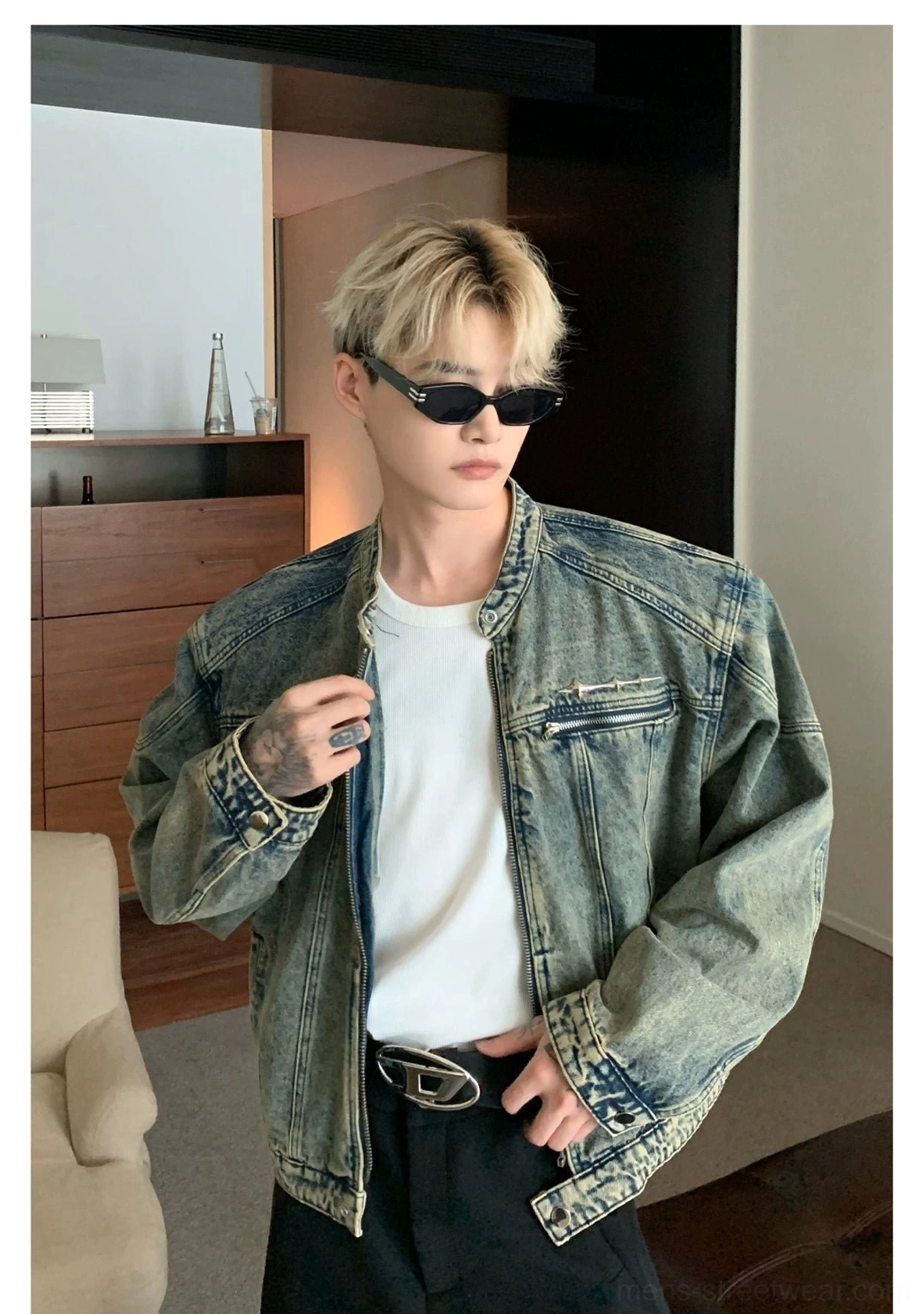 Close front view of distressed blue washed denim moto jacket with snap stand collar and zip pockets