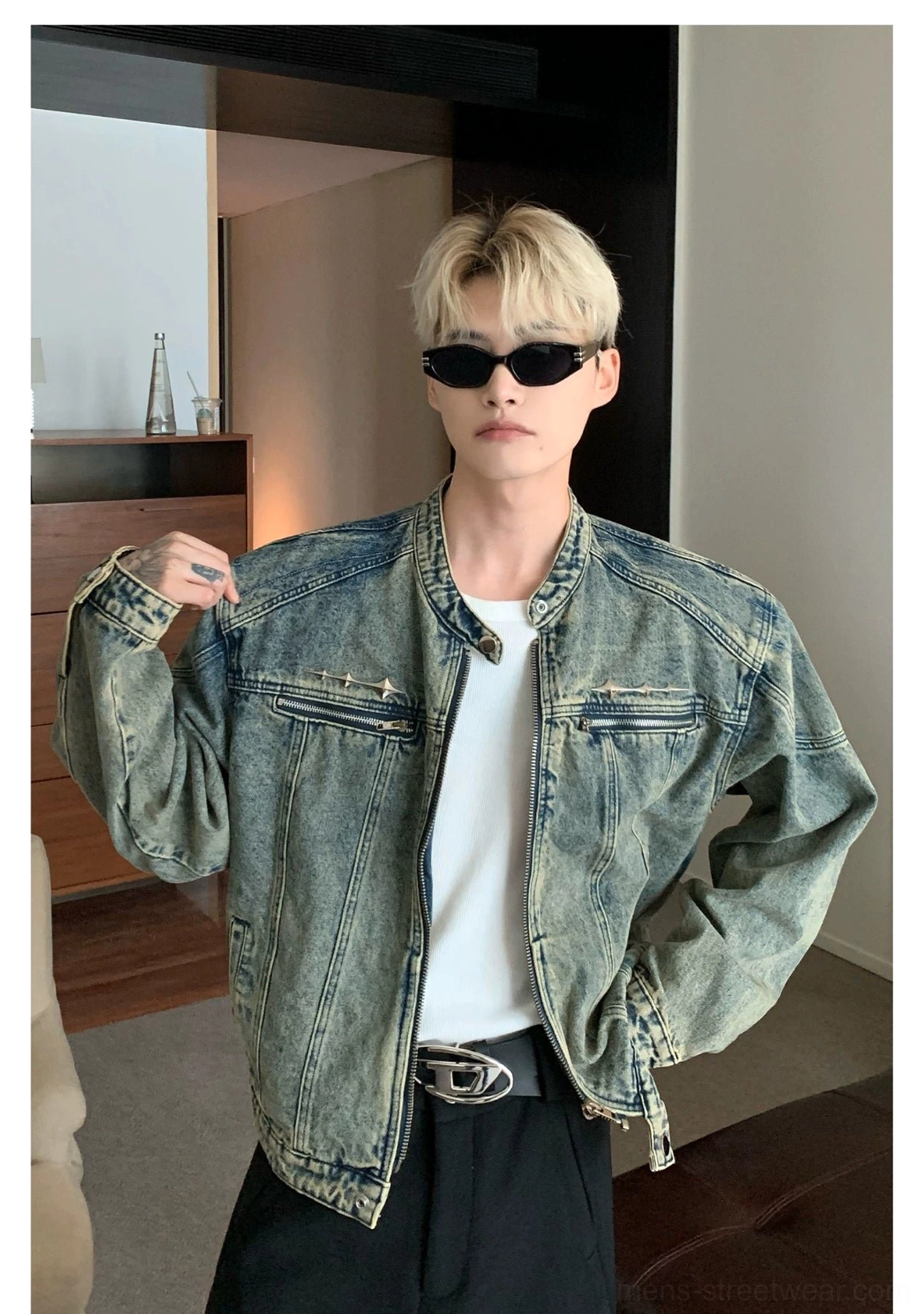 Distressed blue cropped washed denim jacket showing relaxed shoulders and moto inspired silhouette