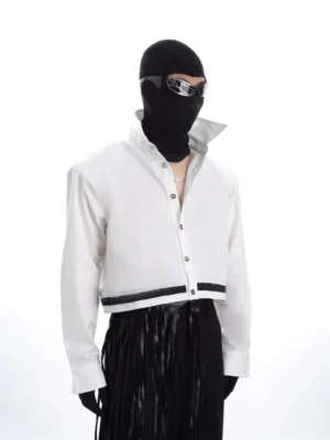 Three-quarter view of a white oversized cropped jacket with futuristic stand collar, long cuffed sleeves, clean front closure, and black contrast hem detail