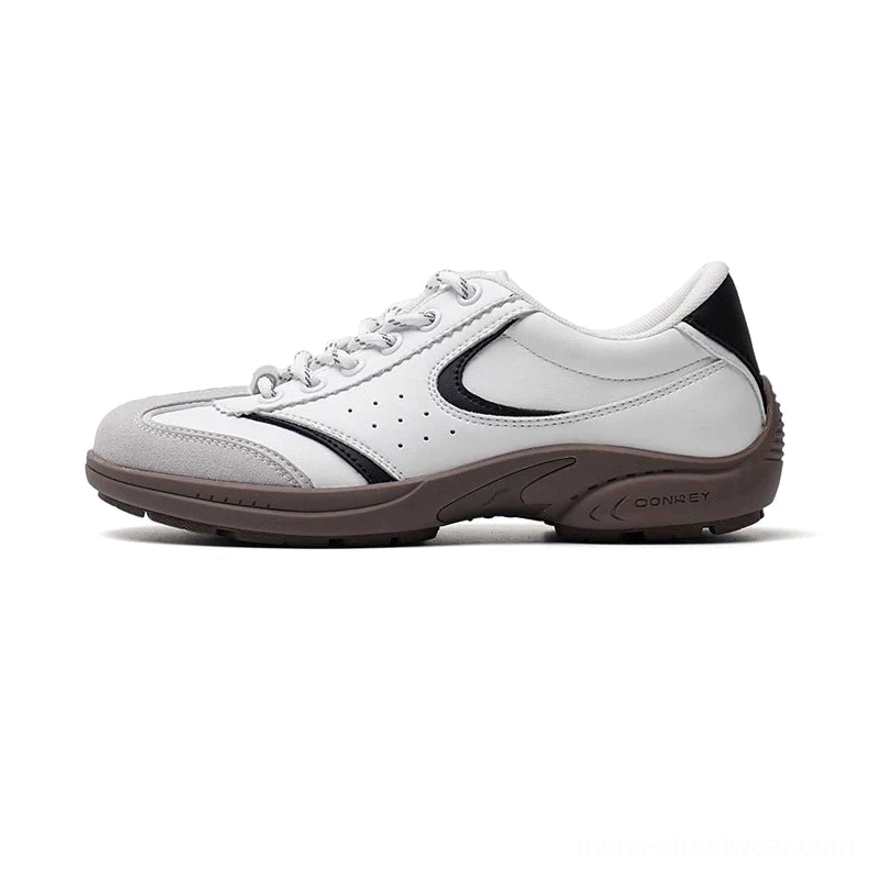 White and black CurveLine retro court sneakers with curved side stripes, perforated toe box, and brown gum rubber sole on a white background