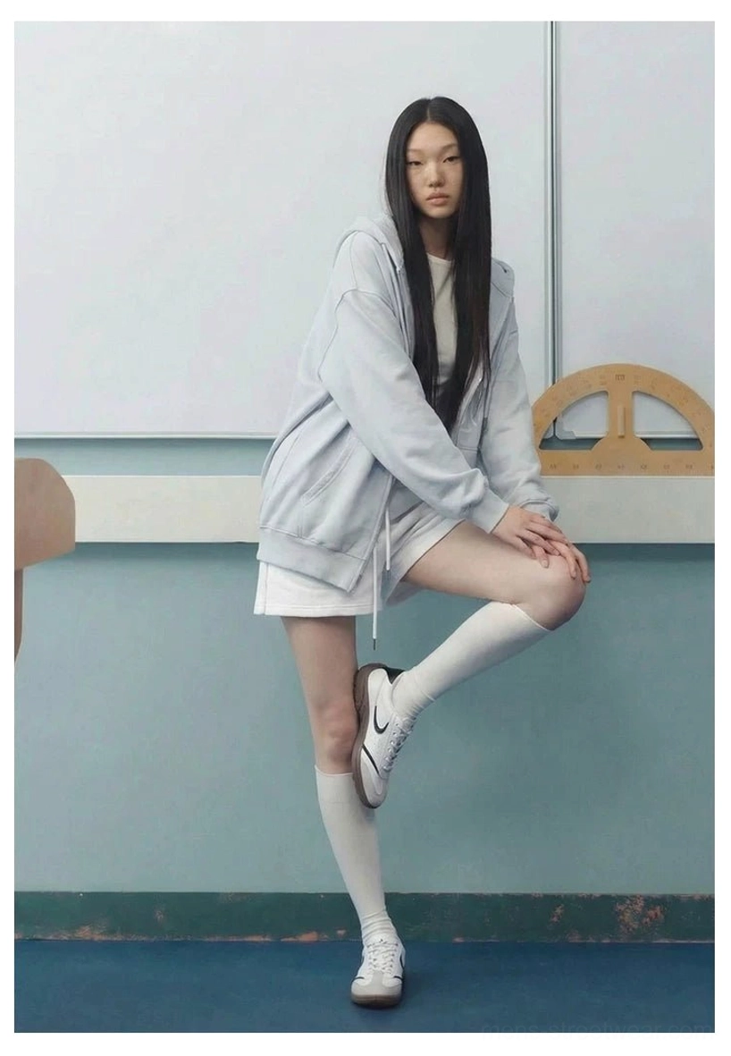 Model wearing white CurveLine retro court sneakers with knee-high socks in a casual Korean streetwear inspired studio outfit