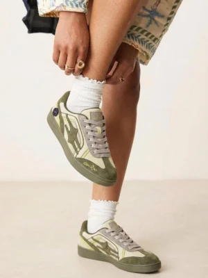 Cyan green flame-panel streetwear sneakers worn with layered jewelry and frilled white socks in a close-up casual fashion styling view