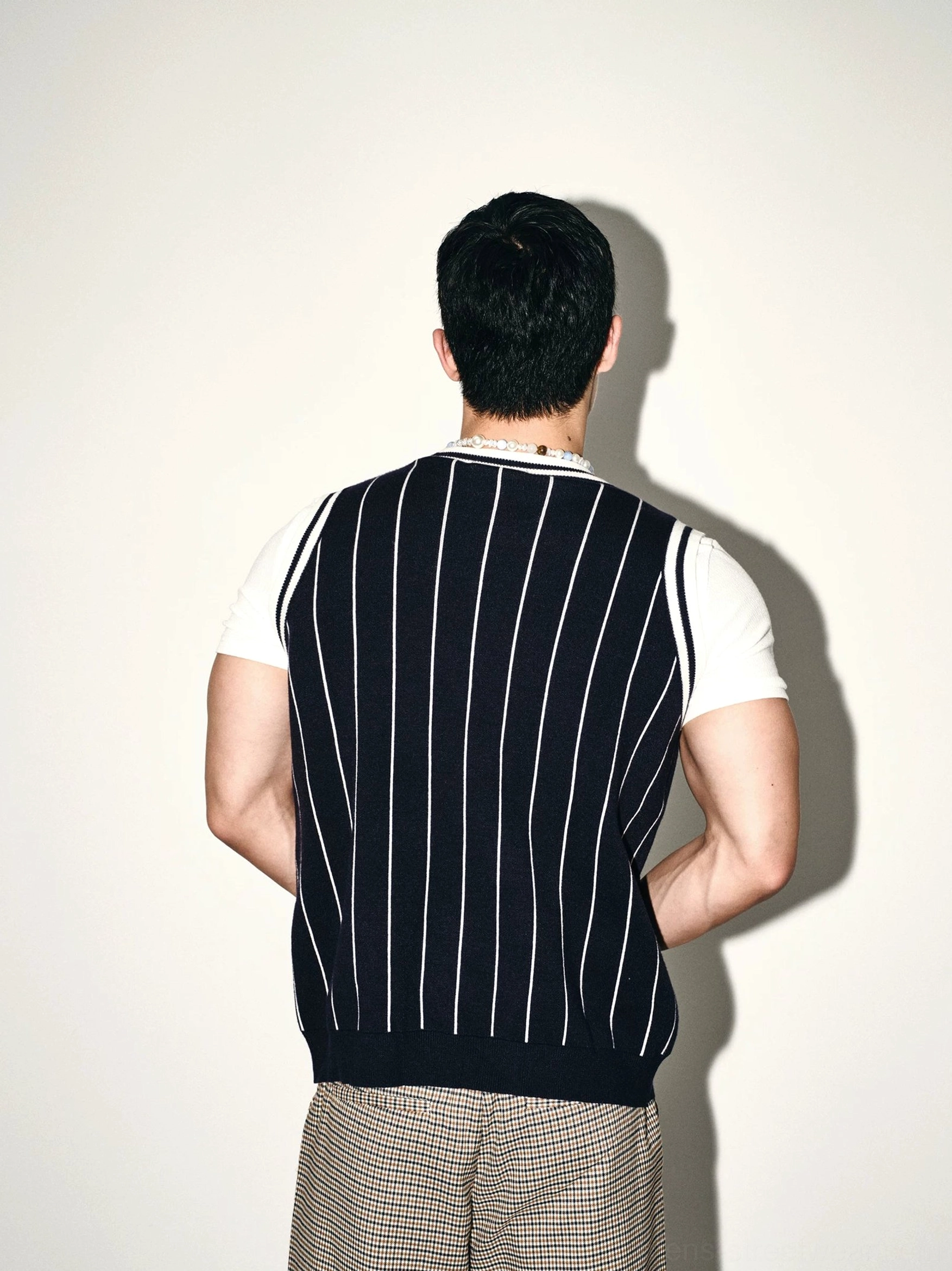 Back view of dark blue pinstripe sleeveless knit basketball vest with clean vertical white stripes and ribbed hem