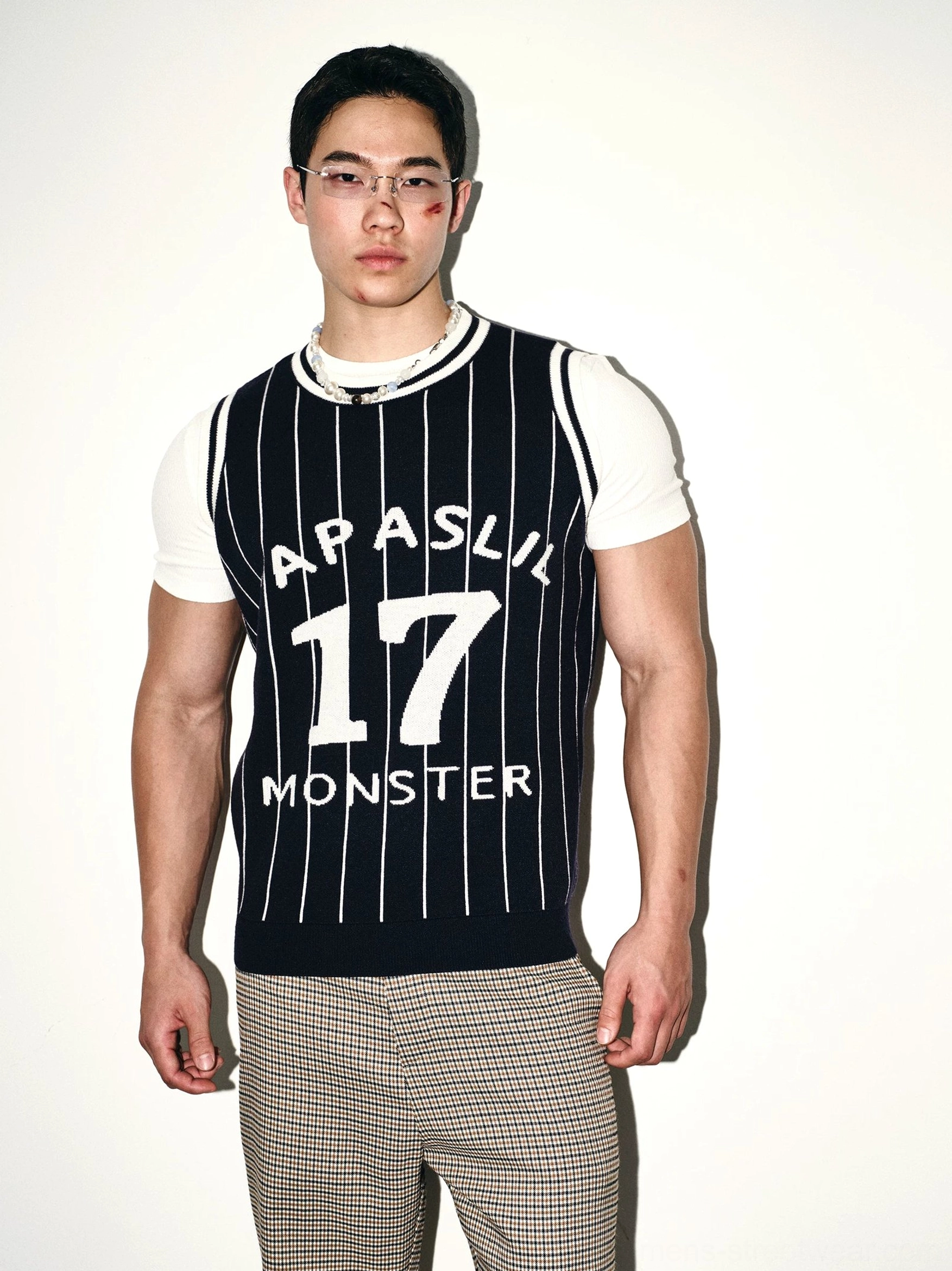 Dark blue pinstripe knit basketball jersey vest front close-up showing white ribbed trim and bold varsity number graphic layered over a white t-shirt