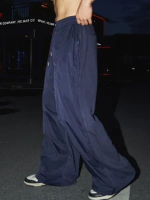 Dark blue wide leg carpenter work pants shown from the side with relaxed fit and elastic drawstring waist