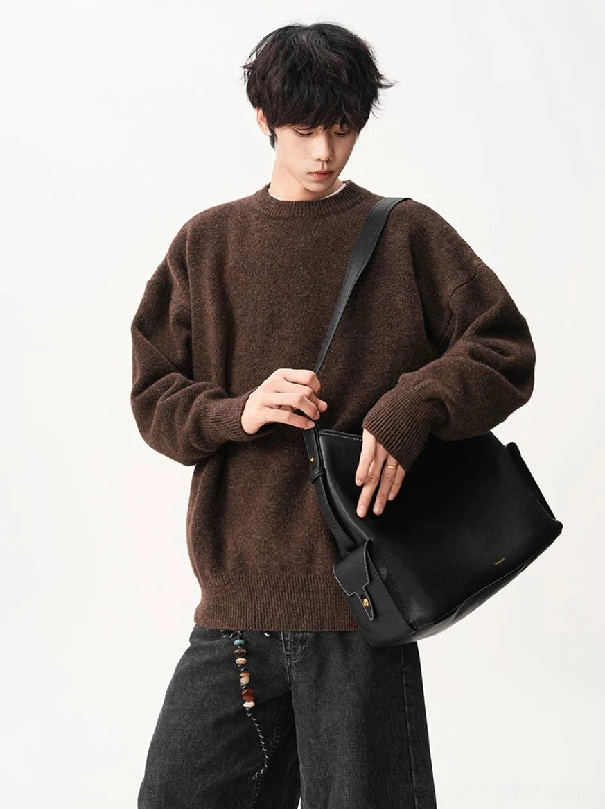 Dark brown oversized textured knit sweater styled with black wide-leg jeans and a black leather tote for contemporary urban streetwear