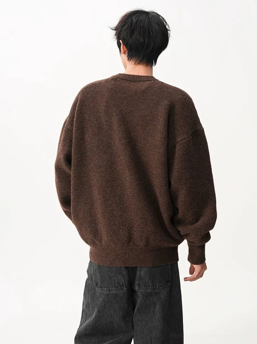 Back view of a dark brown oversized crew neck knit sweater featuring drop shoulder sleeves, soft textured fabric, and a ribbed hem