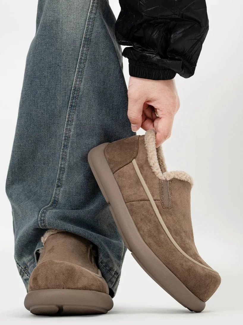 Dark brown shearling-lined slip-on winter clogs worn with baggy jeans, showing the fuzzy collar, suede-finish upper, contrast stitching, and thick rubber streetwear sole