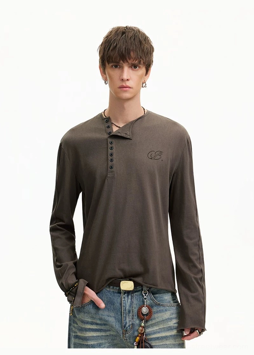 Korean streetwear model wearing a dark brown washed Henley shirt with notched neckline, blue jeans, and gold-tone belt buckle