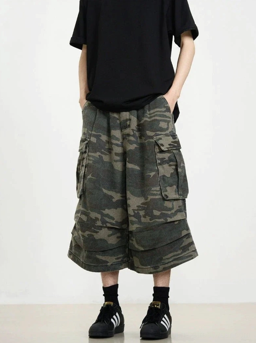 Three-quarter side view of dark camo cargo cropped shorts with loose wide-leg fit and practical flap cargo pockets