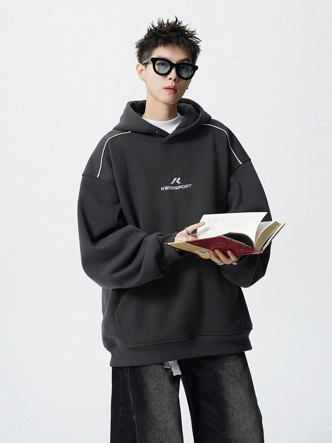 Dark charcoal gray oversized fleece hoodie with white shoulder piping, embroidered chest detail, and relaxed Seoul streetwear silhouette
