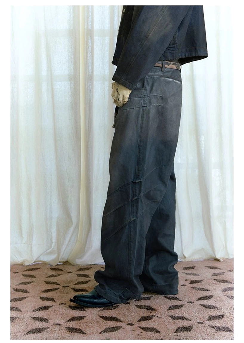 Side and back detail of dark distressed stacked wide-leg jeans with diagonal tailored seams and wide hem