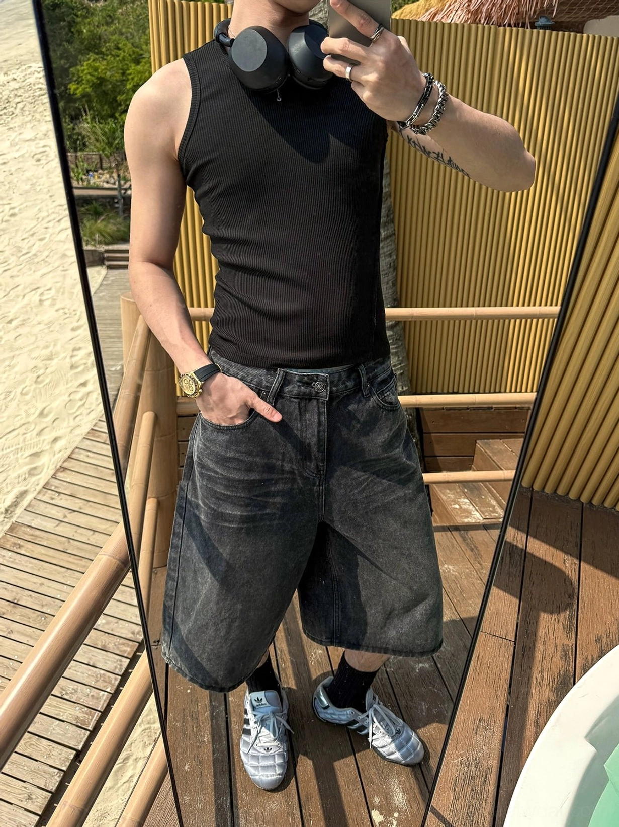 Dark faded blue baggy denim culotte shorts with relaxed wide-leg fit styled with black tank top