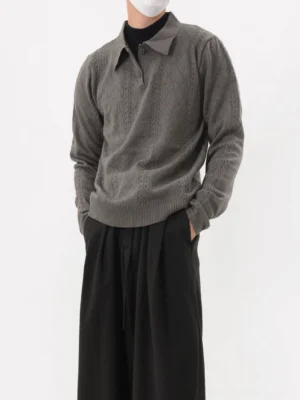 Dark gray cable knit polo sweater shown in a front three-quarter view with textured knit pattern, long sleeves, polo collar, and relaxed Korean streetwear styling