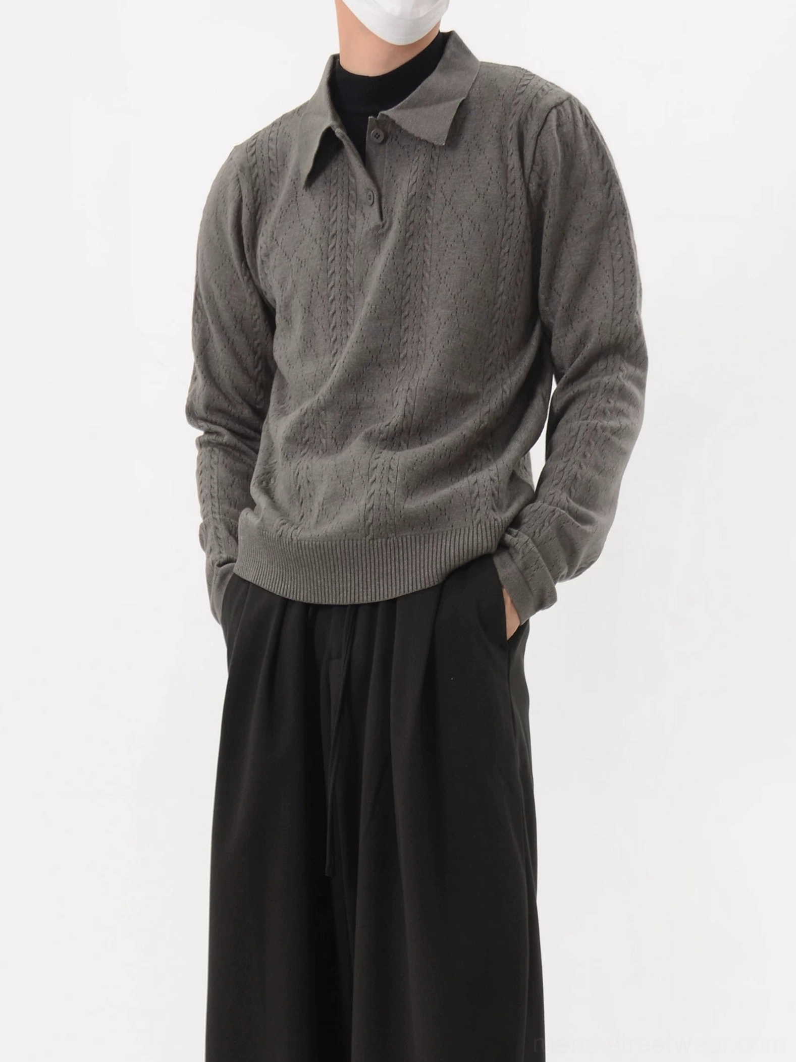 Dark gray cable knit polo sweater shown in a front three-quarter view with textured knit pattern, long sleeves, polo collar, and relaxed Korean streetwear styling