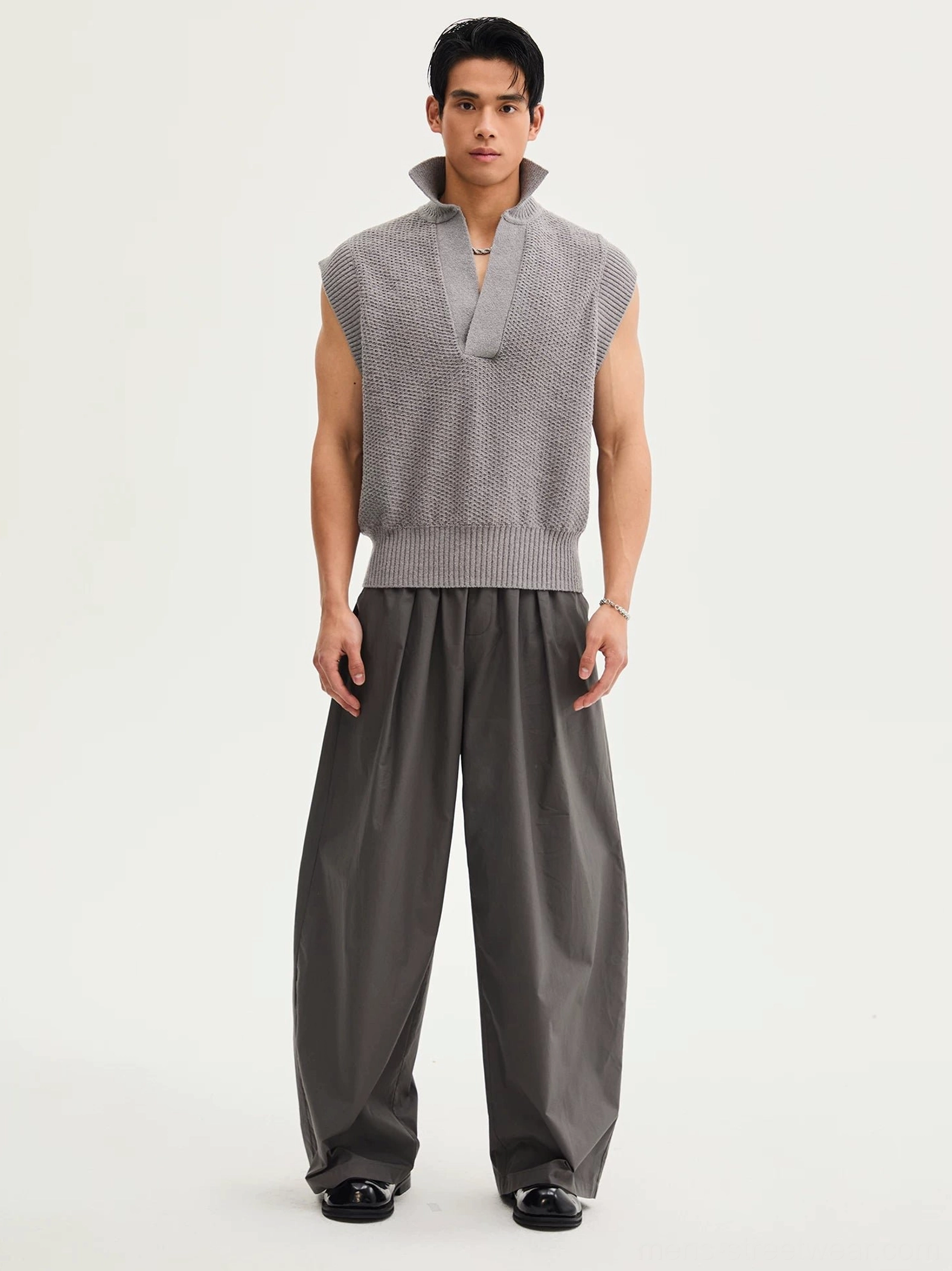 Dark gray curved wide-leg cotton pants styled with leather dress shoes, elastic drawstring waistband, and dramatic draped silhouette
