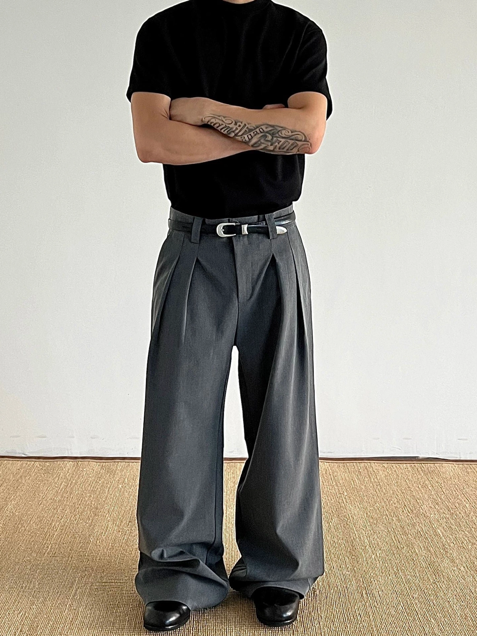 Dark gray double-pleated wide-leg trousers with a silver buckle belt styled for modern Korean streetwear front full-body view
