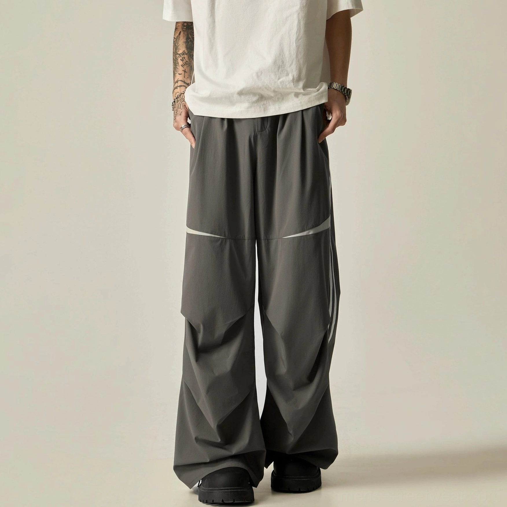 Dark gray dual-stripe wide-leg track pants product image with curved knee panels and oversized contemporary streetwear silhouette