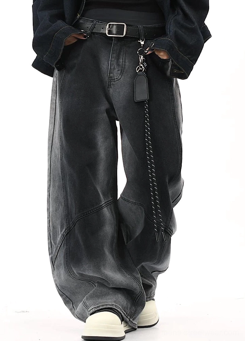 Three-quarter front view of dark gray gradient wide-leg streetwear pants with curved panel construction