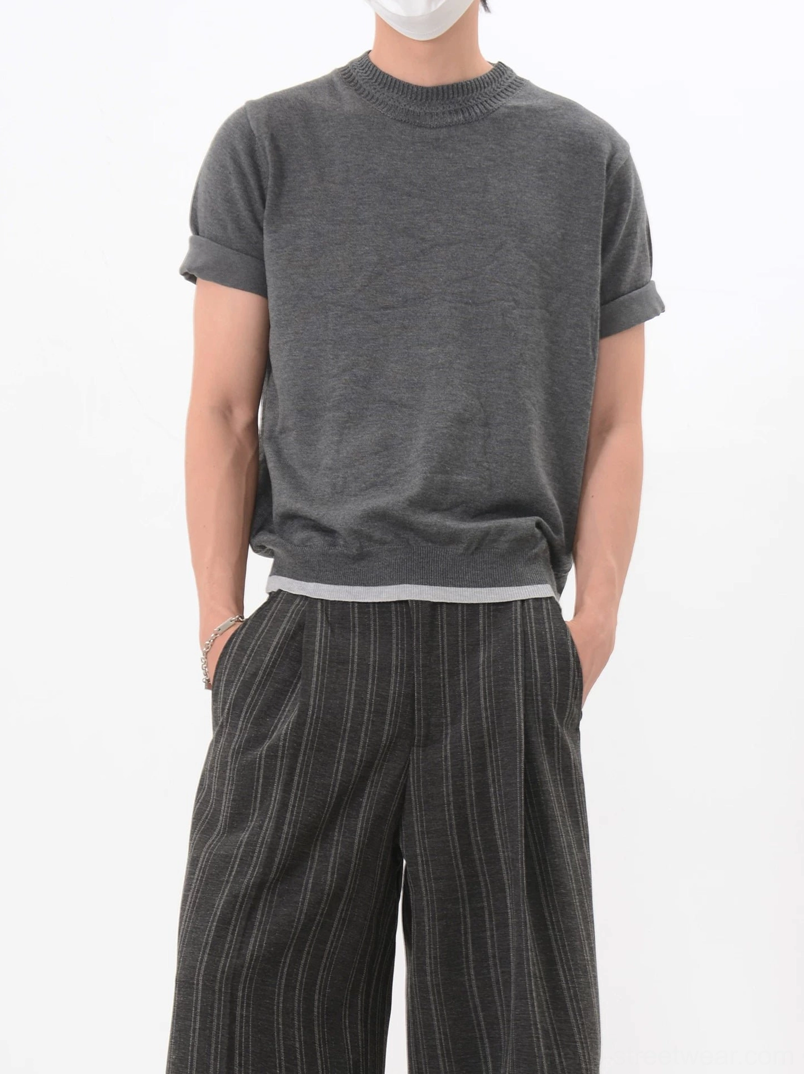 Front three quarter view of a dark gray Korean streetwear knit T-shirt with contrast hem and high waisted striped wide leg pants