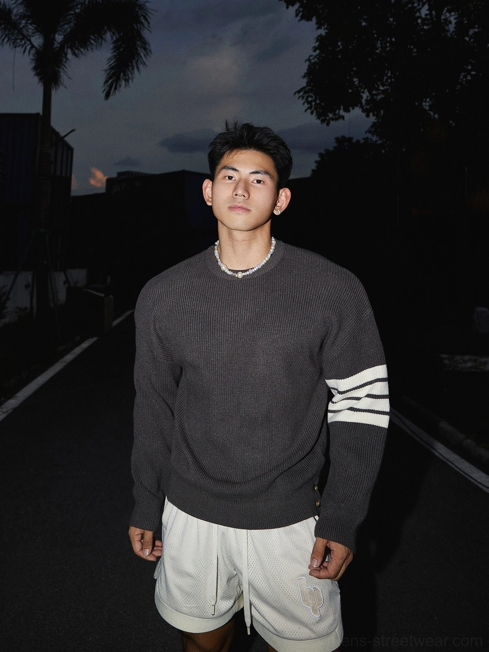 Dark gray Korean streetwear striped sleeve knit sweater with white triple sleeve stripes, loose crewneck fit, and casual white shorts styling