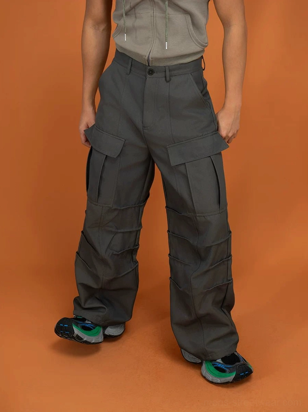 Dark gray oversized cargo pants with layered utility pockets, wide legs, belt loops, and structured Korean streetwear silhouette