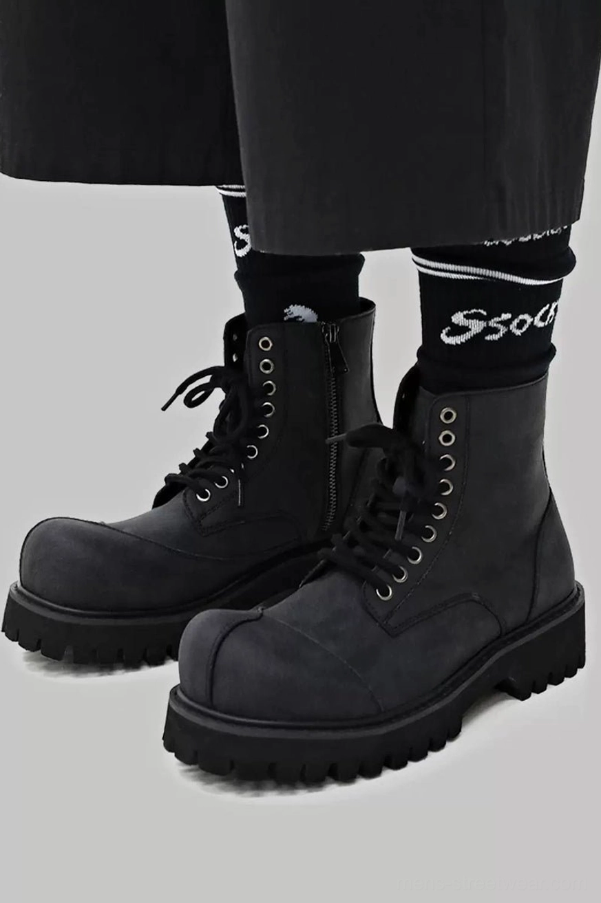 Close-up of deep aggressive lug tread on dark gray suede combat boot EVA outsole