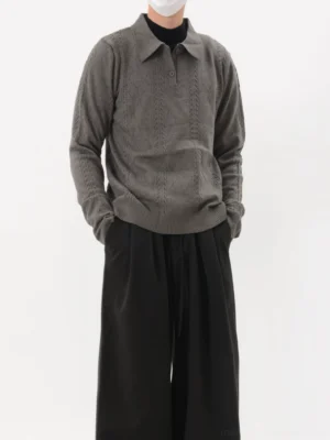 Dark gray textured cable knit polo sweater worn with wide-leg black trousers in a minimalist Seoul-inspired streetwear outfit