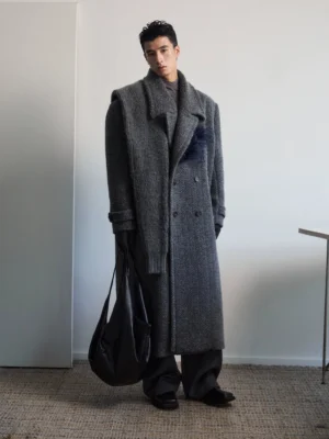 Men's dark gray textured wool double-breasted overcoat with detachable feather-inspired lapel brooch and black leather tote bag