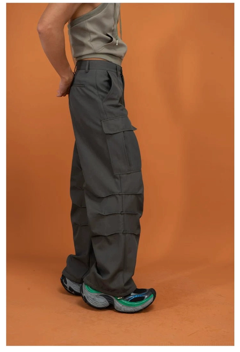 Dark gray utility cargo pants shown from the side rear view with multi-panel pockets and relaxed oversized techwear fit