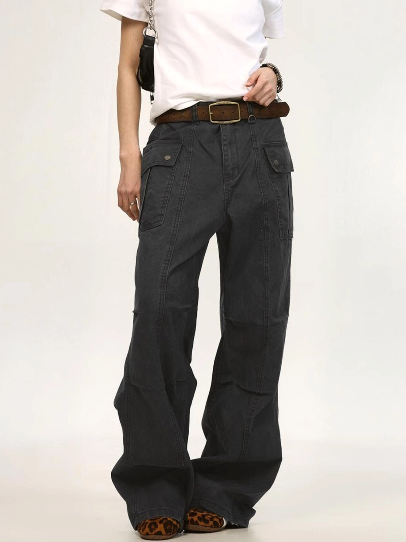 Dark gray washed canvas cargo pants three quarter view with oversized wide legs and side utility pocket