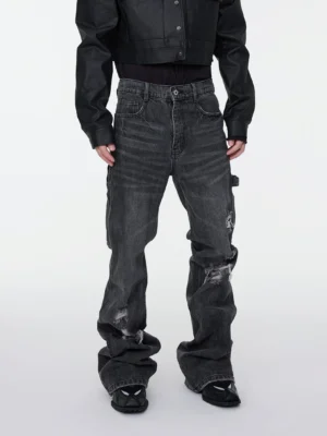 Full body front view of washed charcoal distressed stacked denim cargo jeans with faded whiskering and flared hems