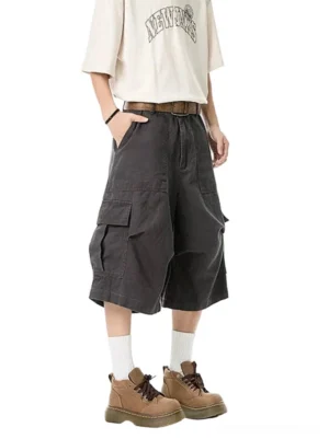 Dark gray wide-leg cargo shorts with large flap pockets shown on a male model in a Korean streetwear outfit