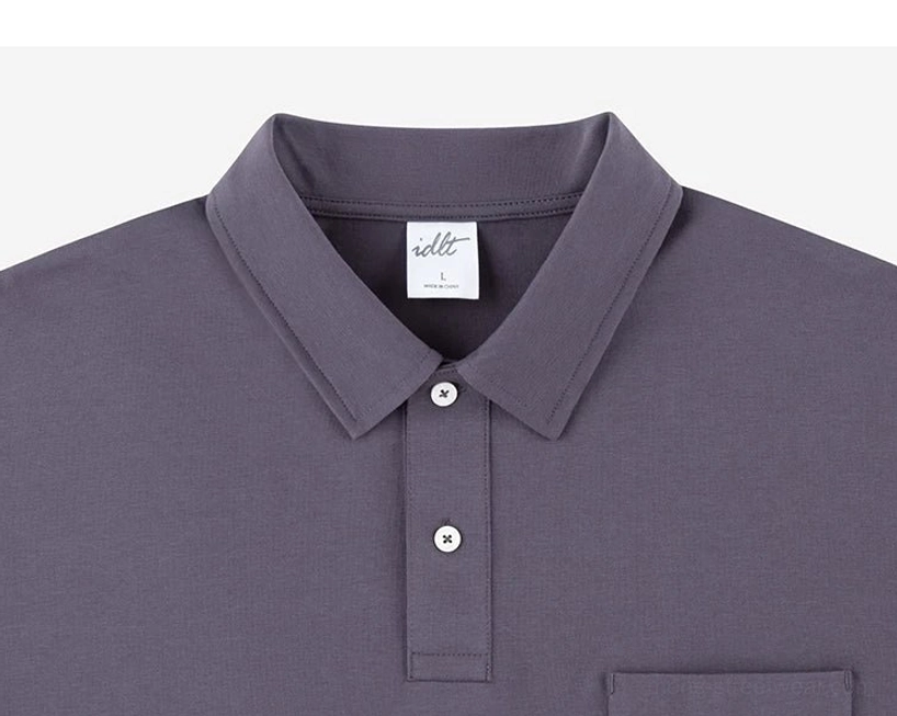 Upper body detail of dark grey cotton blend technical polo shirt with relaxed collar, two button placket, and chest pocket