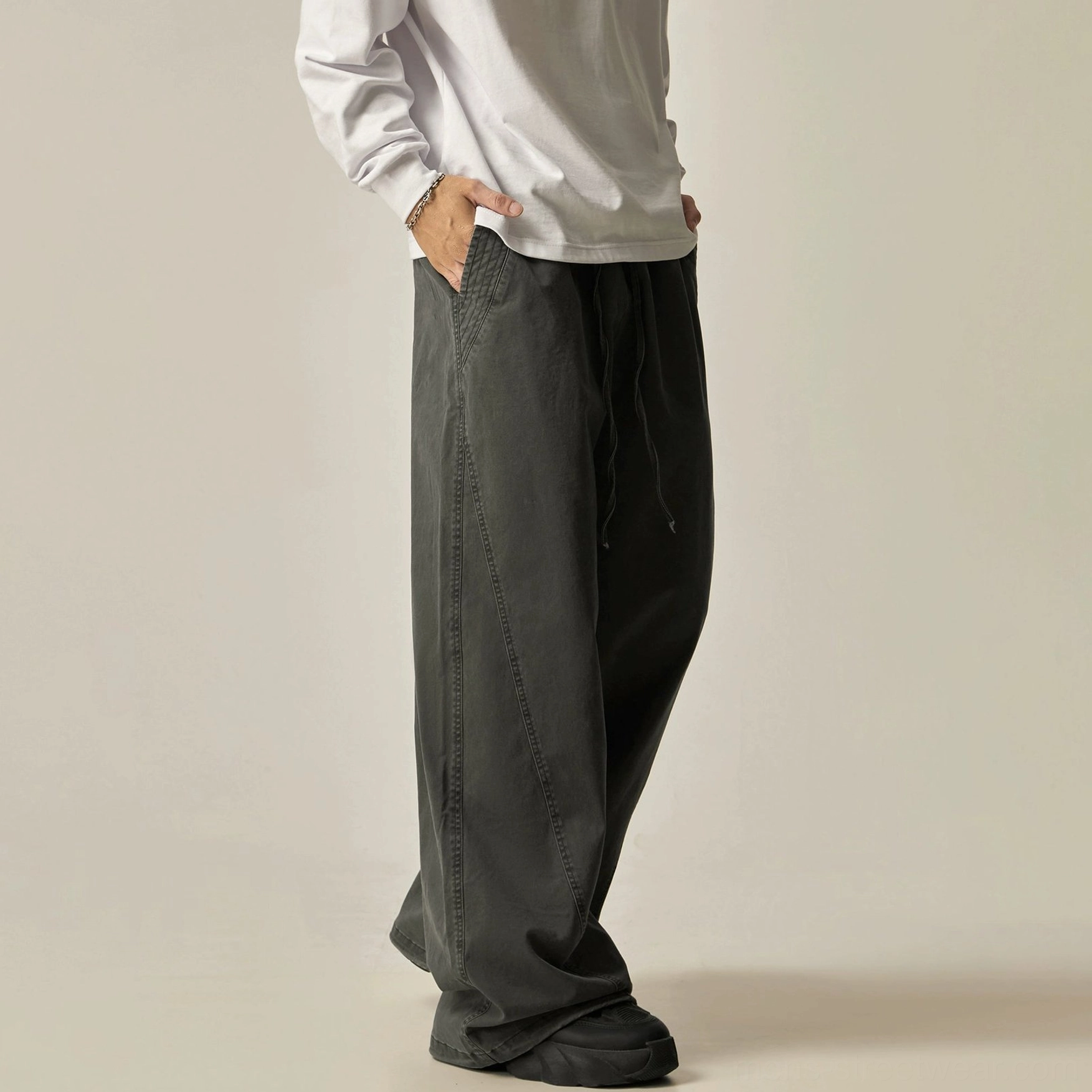 Dark grey drawstring wide-leg pants floor-length hem charcoal washed fabric oversized proportions contemporary streetwear pooling