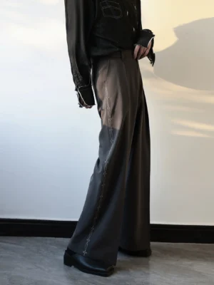 Dark grey wide-leg tailored pants with chain side embroidery styled with a black distressed shirt and leather loafers